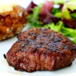 A top sirloin on a plate with potato and salad
