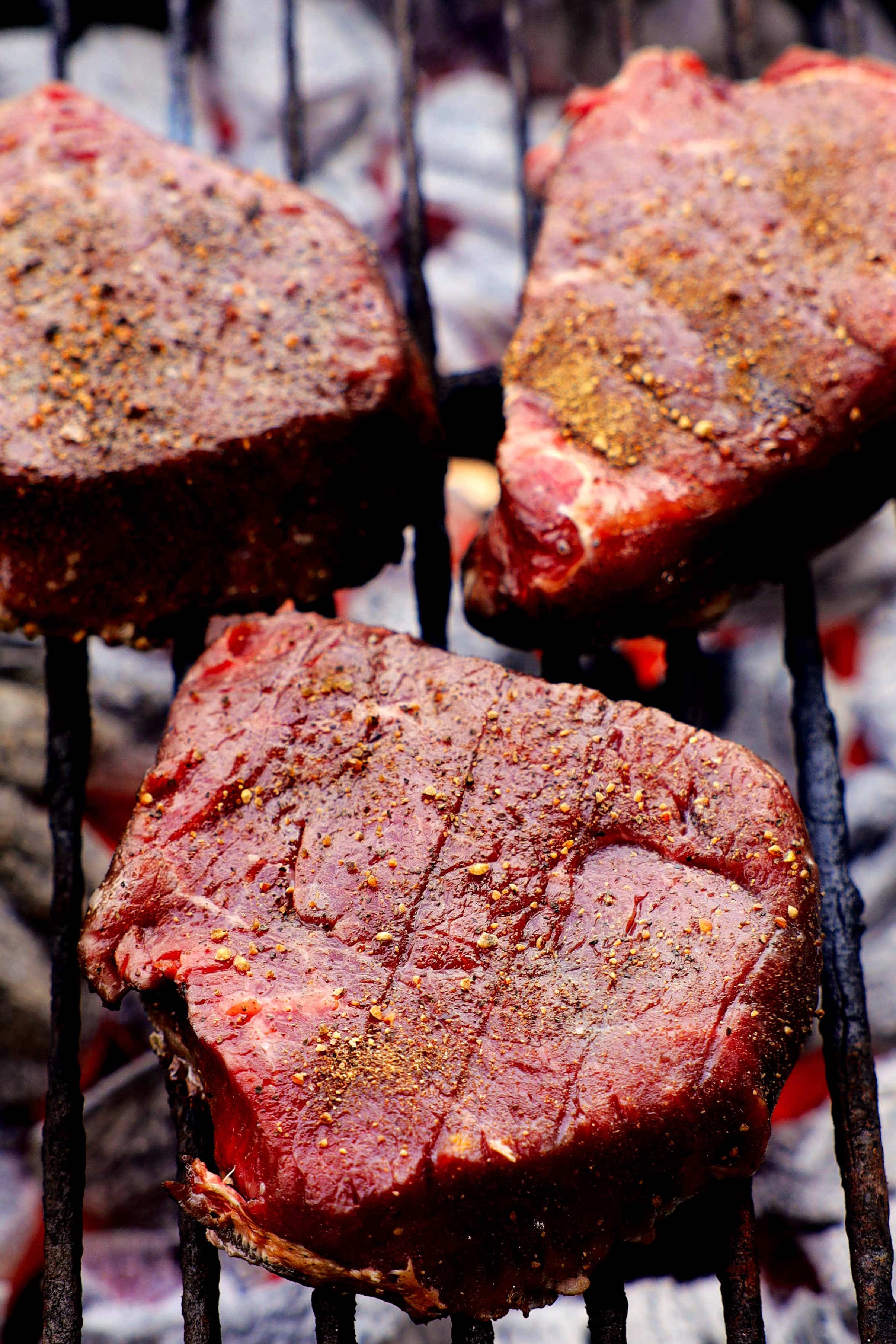 three top sirloins on a charcoal grill