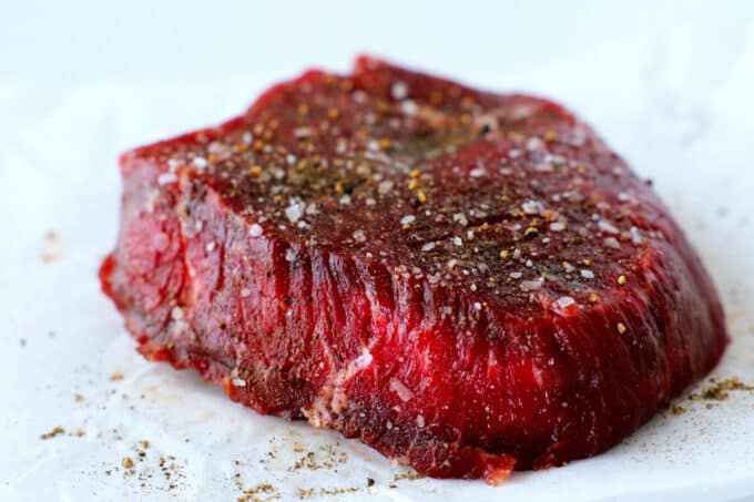 a raw sirloin steak with salt and pepper