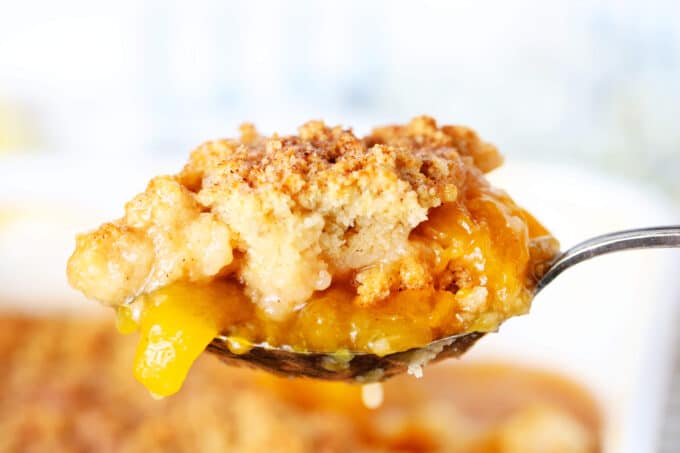 a close up of peach cobbler on a spoon