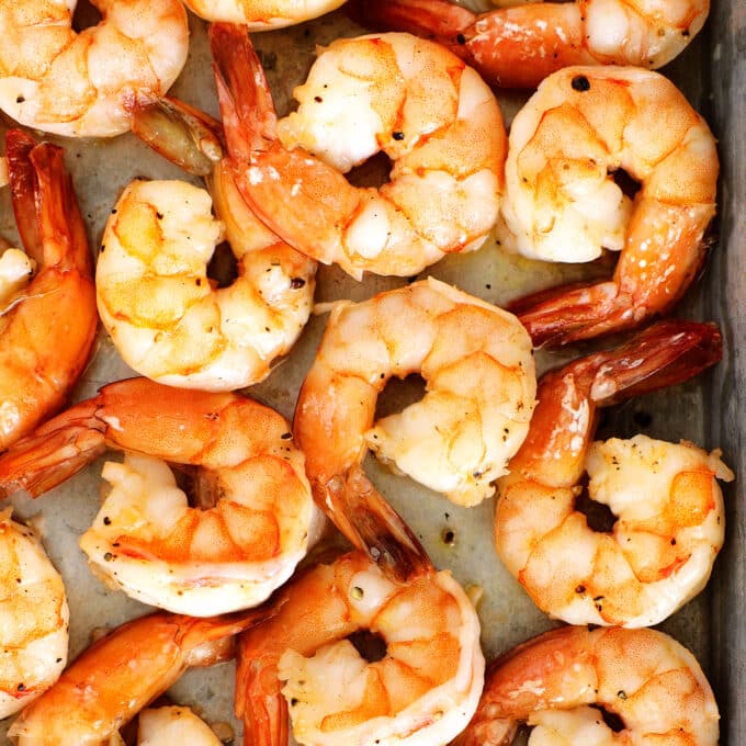 an overhead view of roasted shrimp on a baking sheet