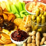 A side view of a southern appetizer board showing okra, peanuts, crackers, cheeses, fruit, and veggies