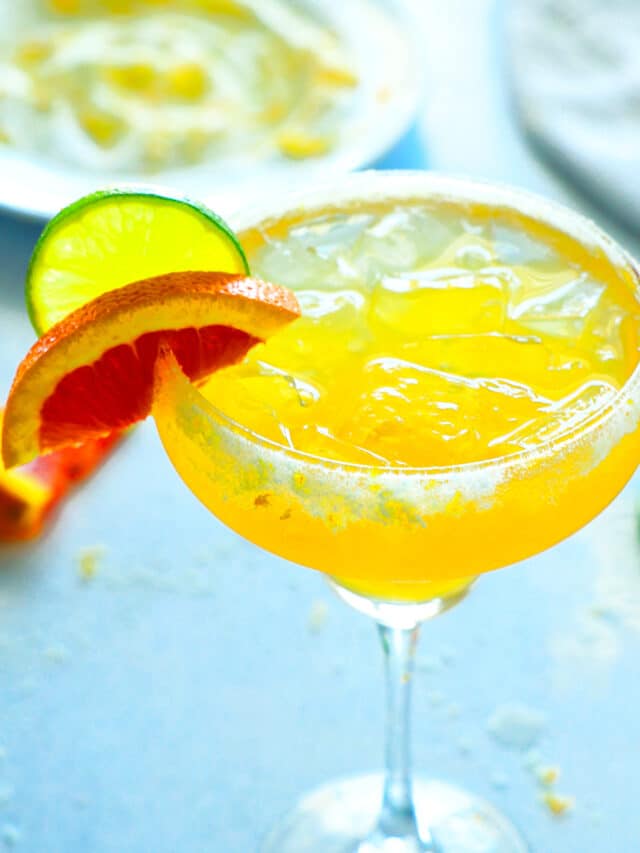an Italian Margarita with lime wheel and orange wedge on the side