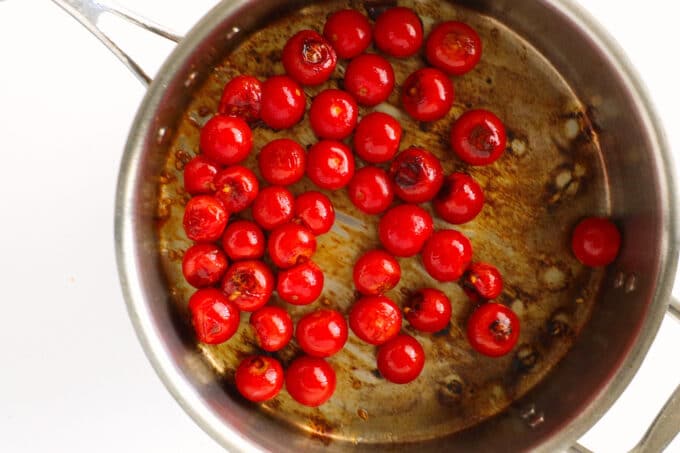 overhead view of tomatoes in a saucepan, starting to blister