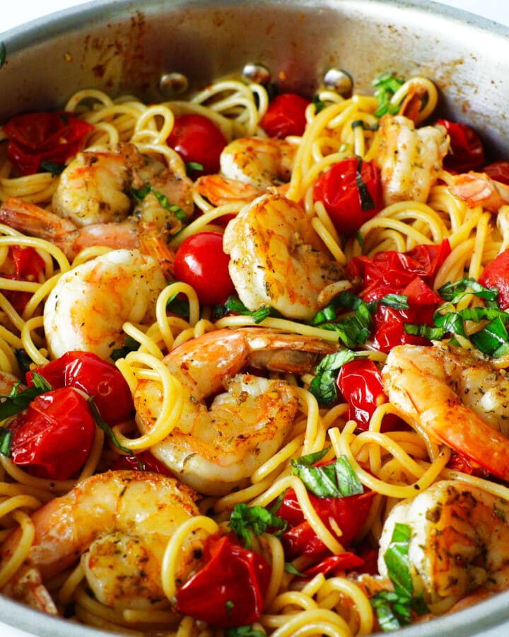 a big bowl of shrimp spaghetti. noodles, tomatoes, basil, shrimp