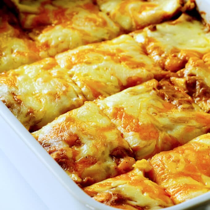A close up of beef enchilada casserole cut into serving sized squares