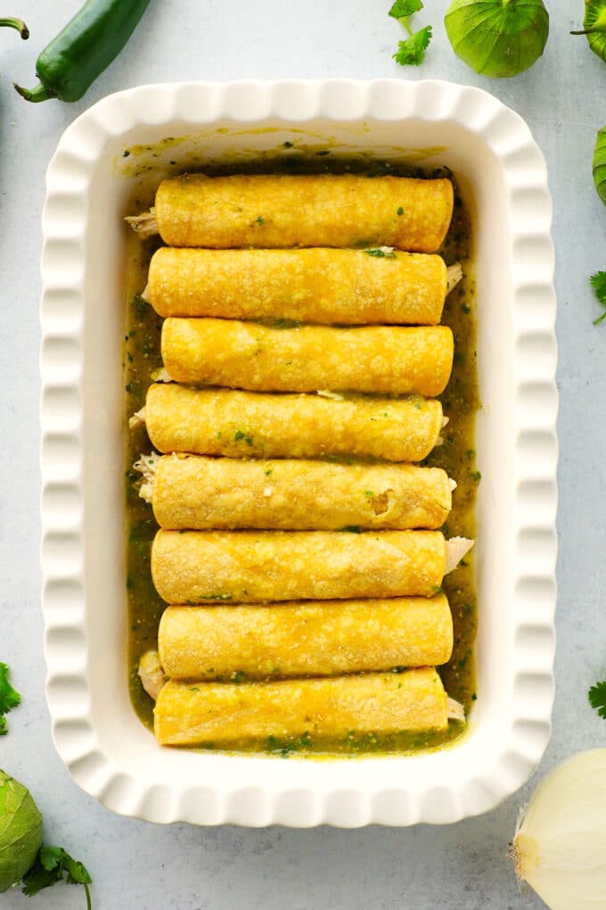 An overhead view of a pan of enchiladas, all rolled up but before the sauce has been added