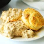 A close up of biscuits with creamy sausage gravy on top