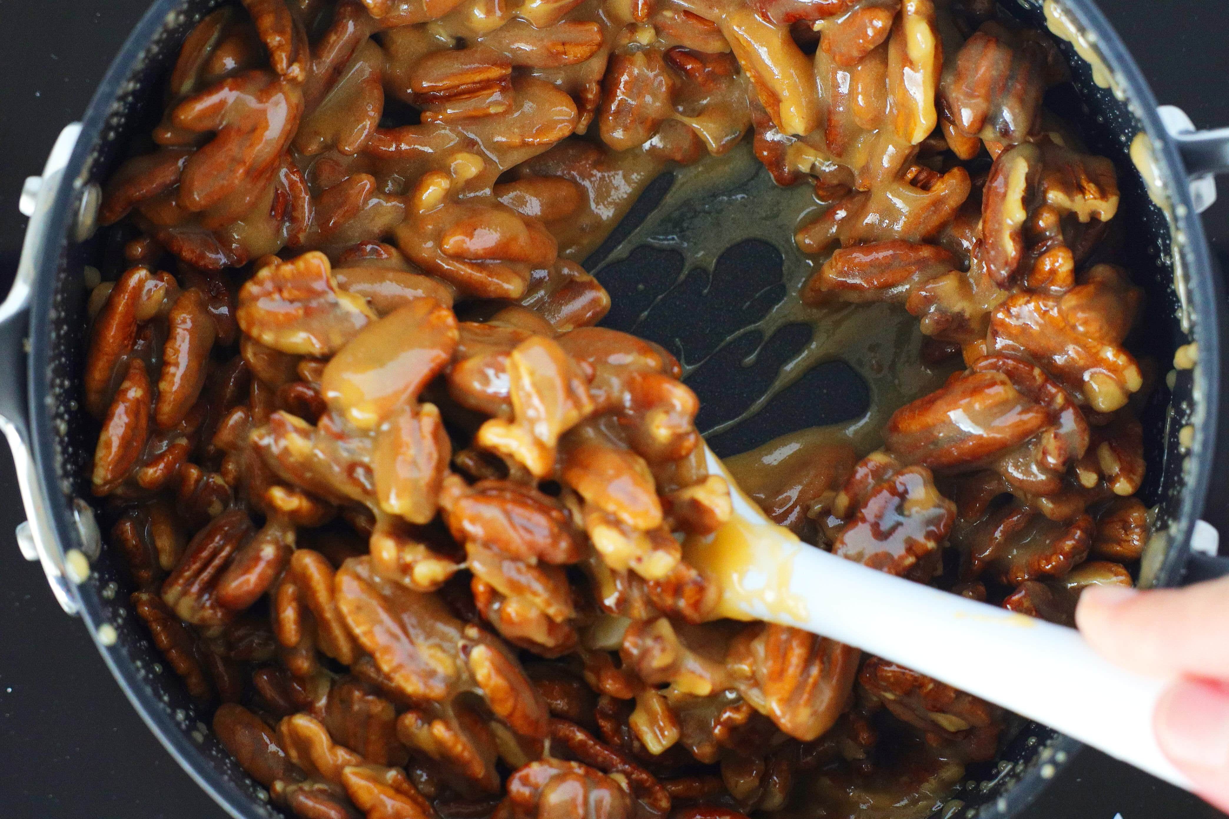 Stirring pecans into candied mixture for praline pecan recipe
