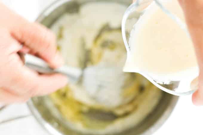 heavy cream being streamed into the roux while it's whisked