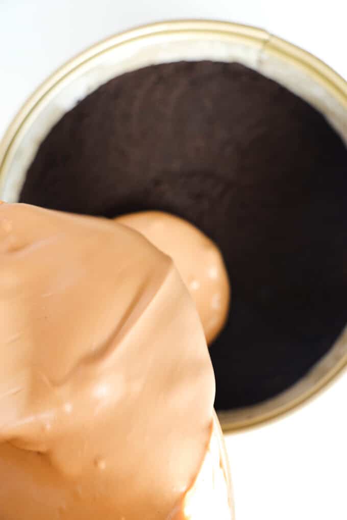 Chocolate mousse being poured onto the cookie crust