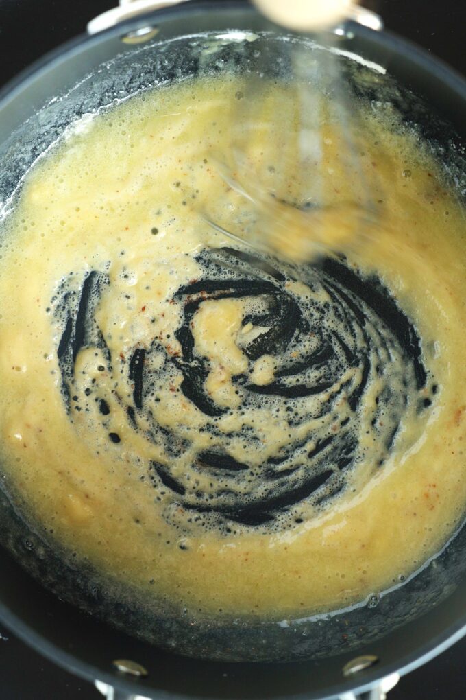 the roux being mixed in a saucepan 