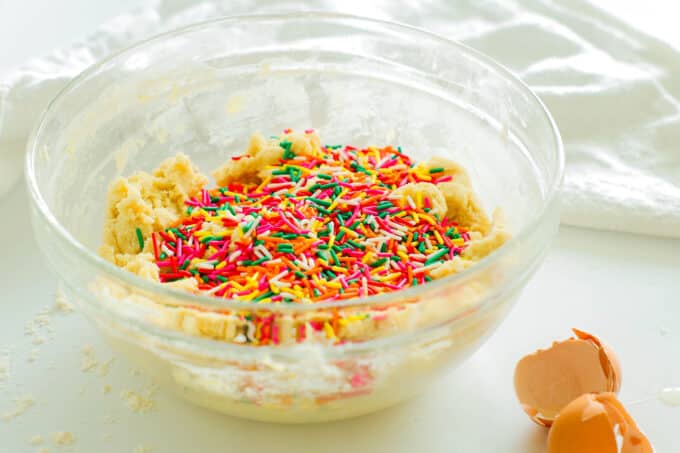 A bowl of cookie dough with the sprinkles added but not yet mixed in.