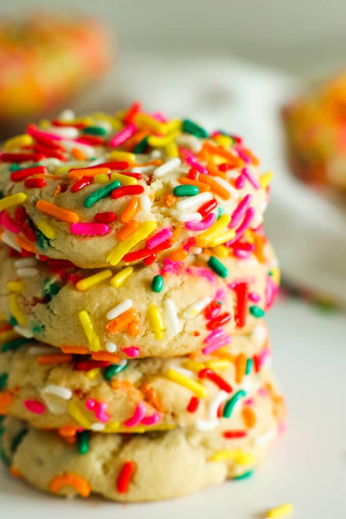 A stack of four Funfetti Cookies, covered in colorful sprinkles