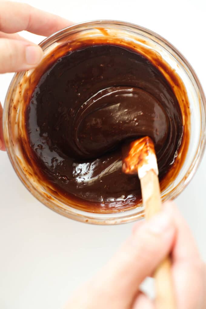 The cream and chocolate mixture being stirred with a rubber spatula.