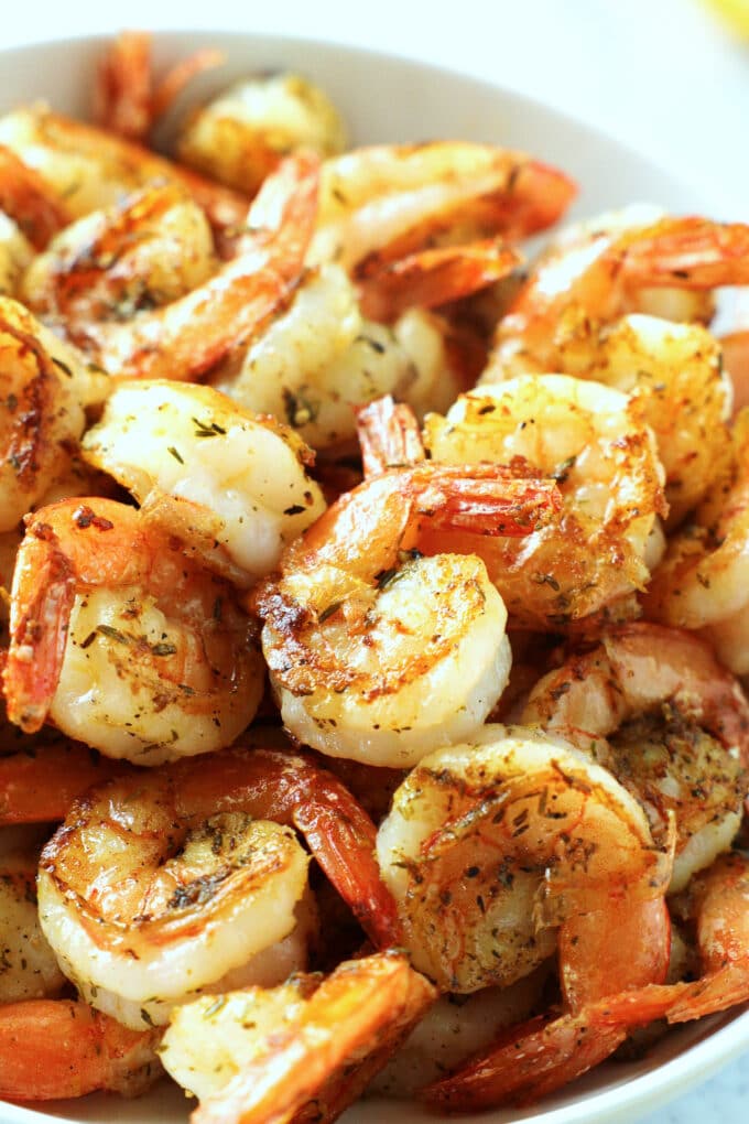 A close up of a bowl of pan-seared shrimp. It looks juicy and lightly browned