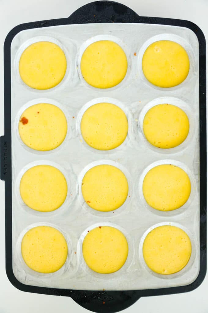 A silicone muffin pan with each cup full of the egg mixture, ready to bake.