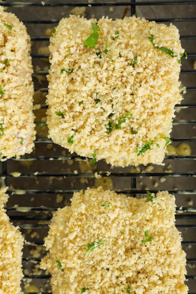 The breaded fish fillets sitting on top of the cooling rack, ready to bake.