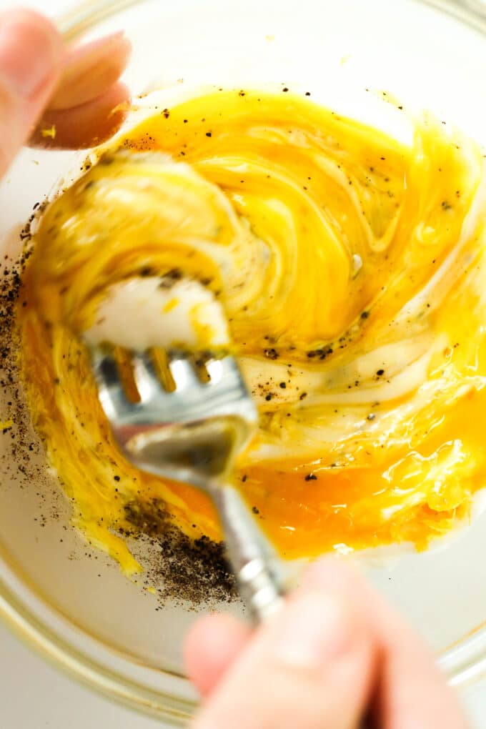 The egg mixture being whisked together with a fork.