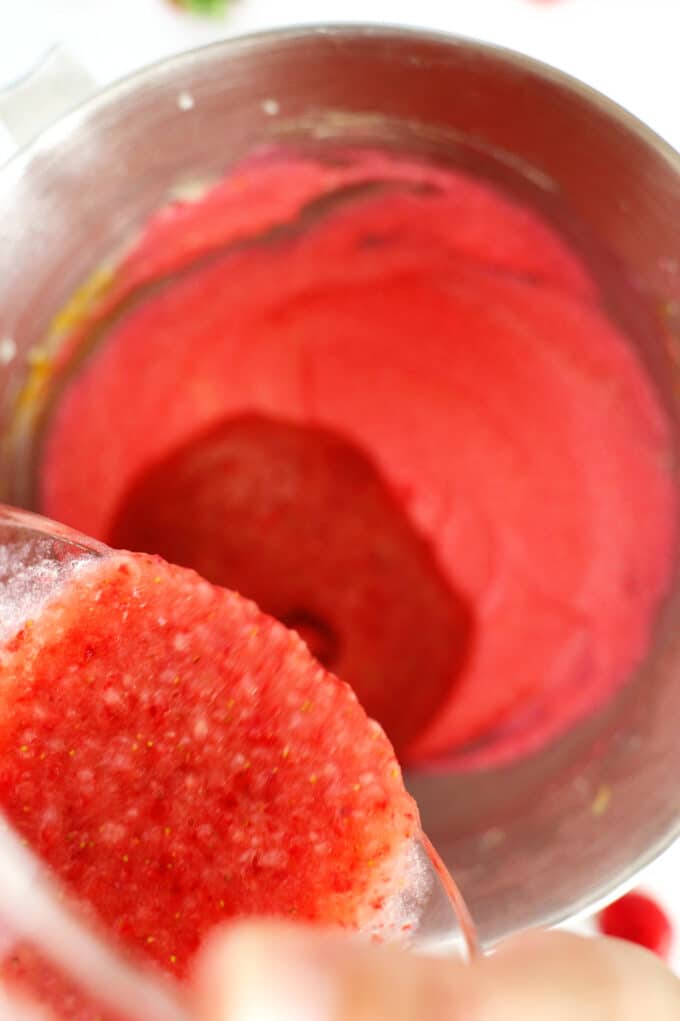 The strawberry purée being poured into the pink cake batter.