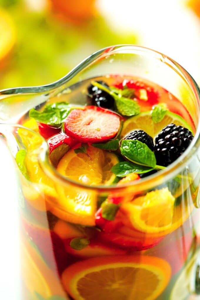 A close up of the top of the pitcher of White Wine Sangria. It is full of vibrant and colorful fruit.