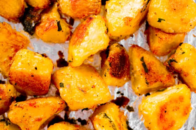 An overhead view of Crispy Roasted Potatoes on a foil lined pan. They are toasty and golden-brown.