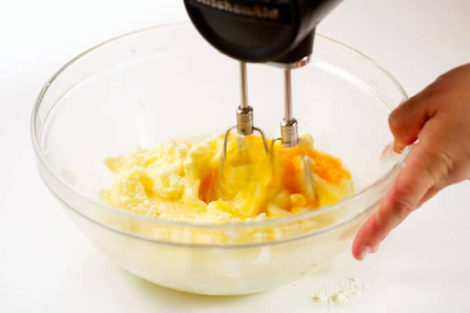 The eggs being incorporated into the creamed butter and sugar with a hand mixer.