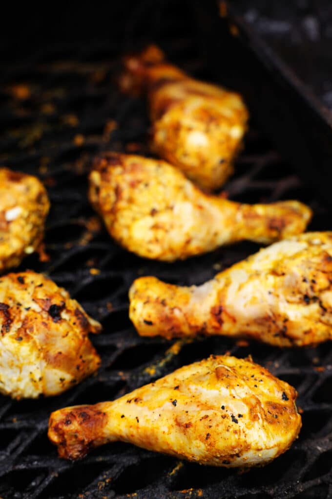 Chicken legs being cooked on a smoker.