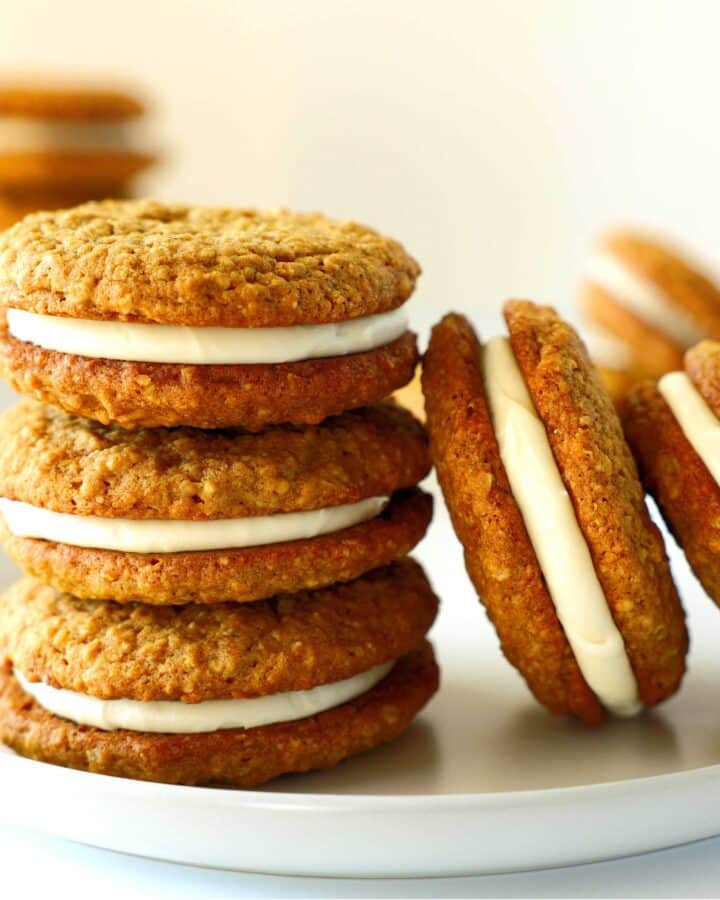 A stack or three Oatmeal Cream pies with two other leaning against the stack. They are all on a white plate.