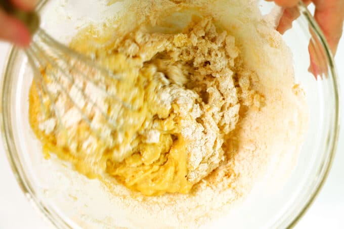 The wet and dry Peach Cake ingredients being combined with a whisk.