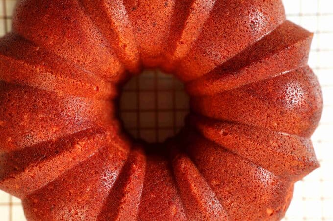 A Strawberry Pound Cake once it's been turned upside down onto the cooling rack. The outside is a dark red color.