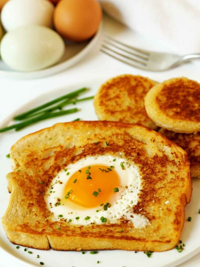 Eggs in a Basket with chives on the side and a bowl of white and brown eggs in the background.