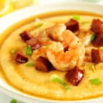 A bowl of Shrimp and Grits with chopped green onion sprinkled over the top.