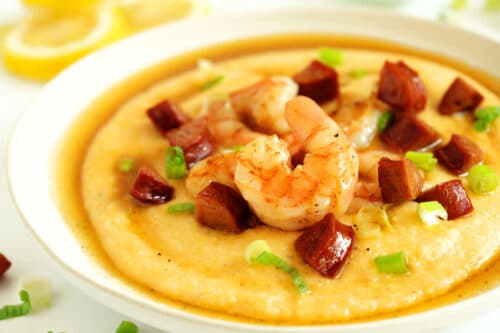 A bowl of Shrimp and Grits with chopped green onion sprinkled over the top.