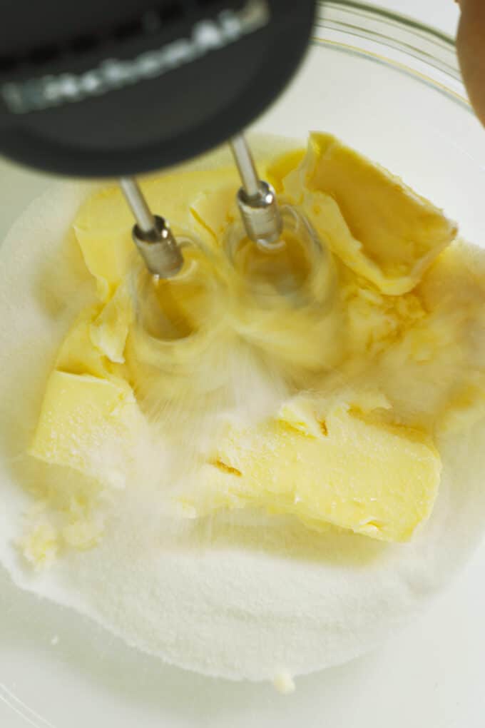 Butter and granulated sugar being creamed together with with a hand mixer.