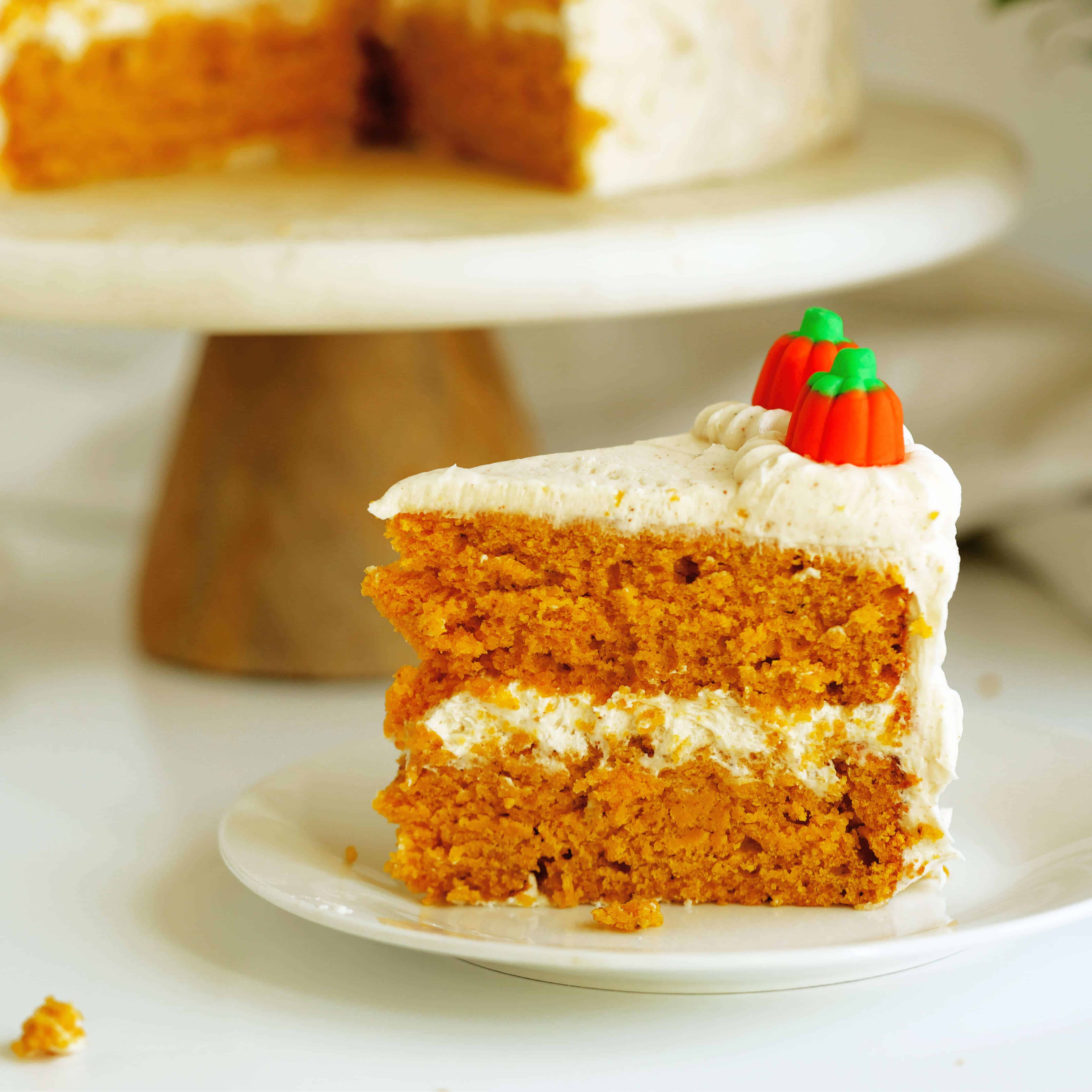 Slice of Pumpkin Cake with Cream Cheese Frosting on a white dessert plate