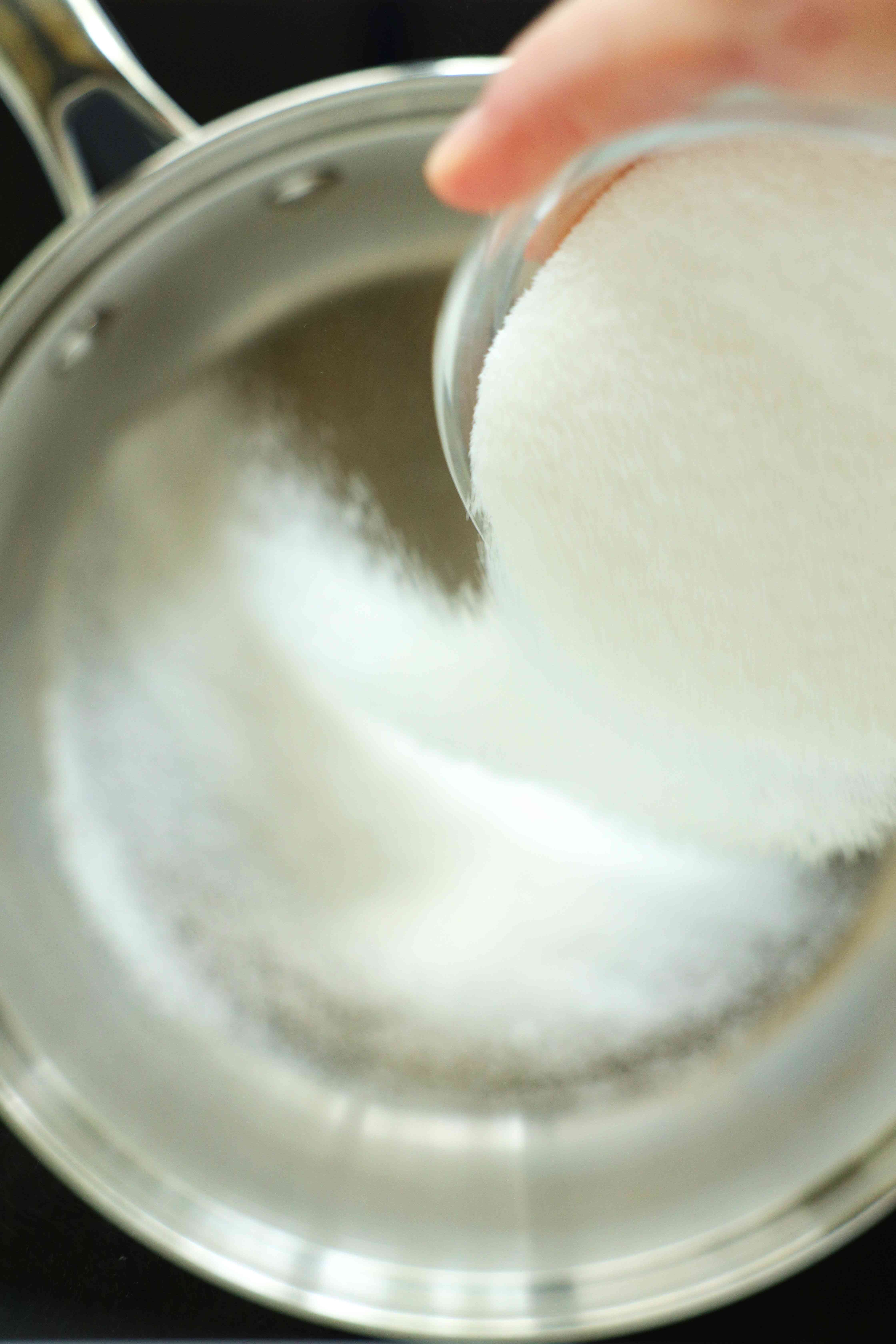 Sugar being poured into a mixing bowl