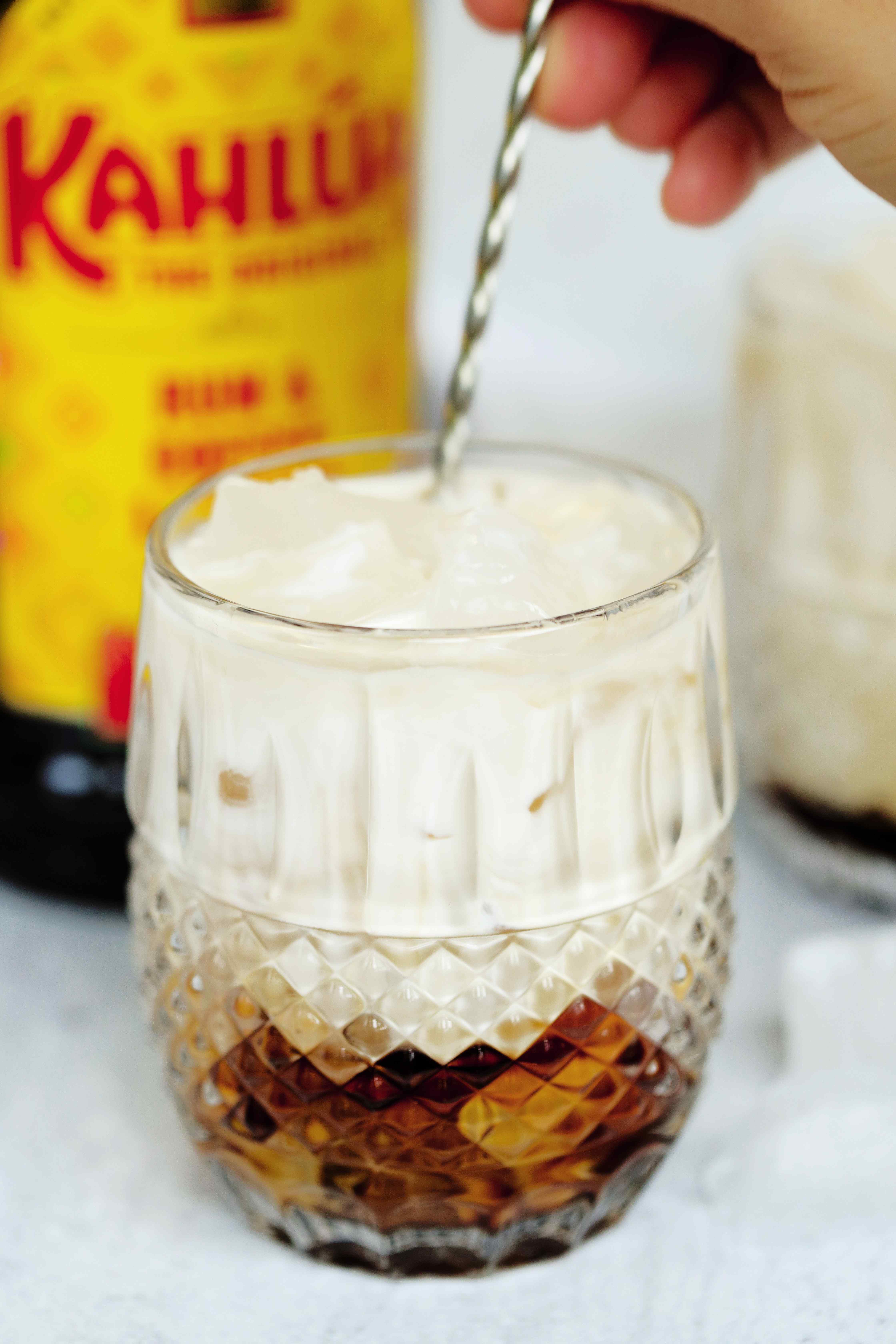 Prepared White Russian in a rocks glass being stirred