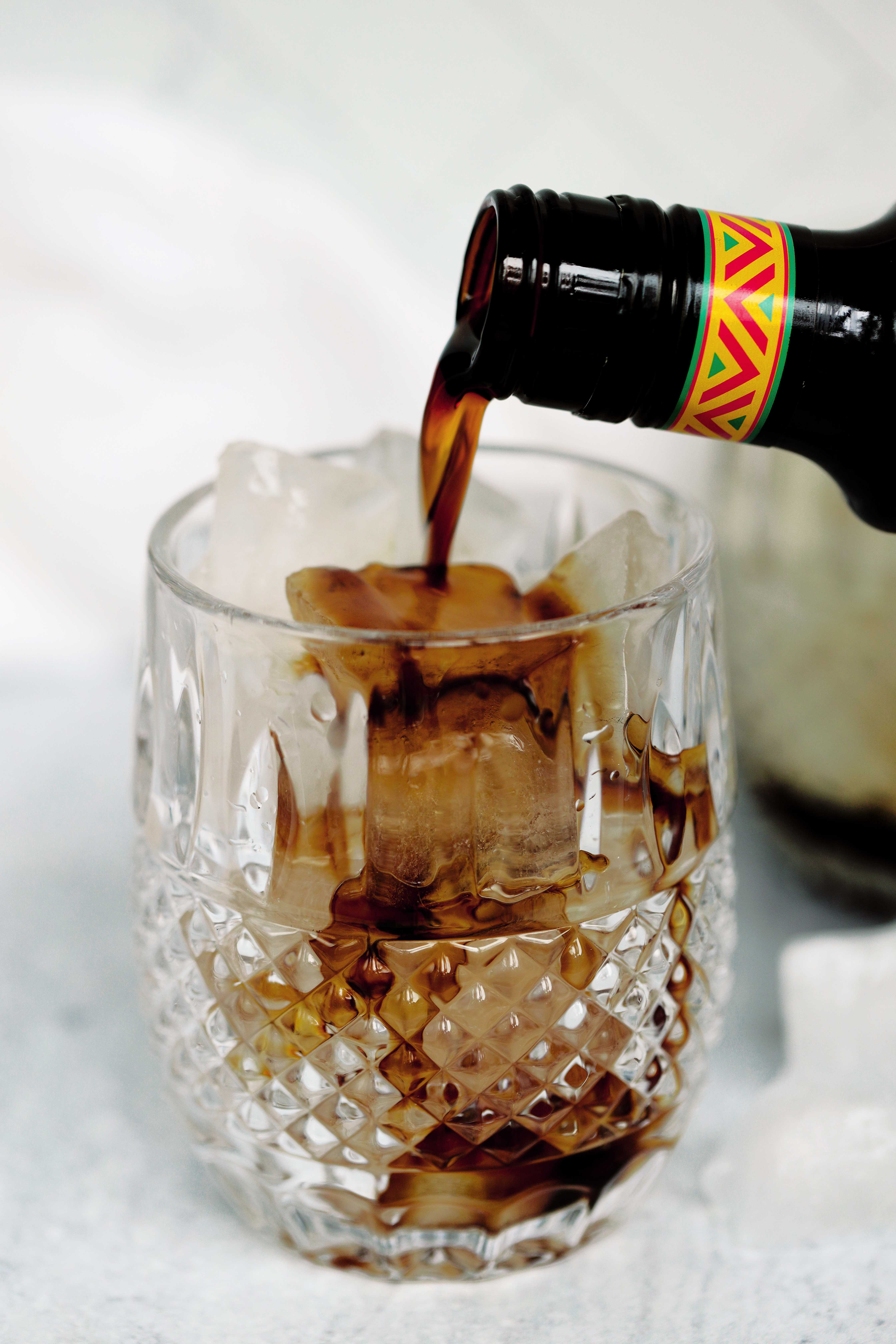 Kahlua being poured into a rocks glass