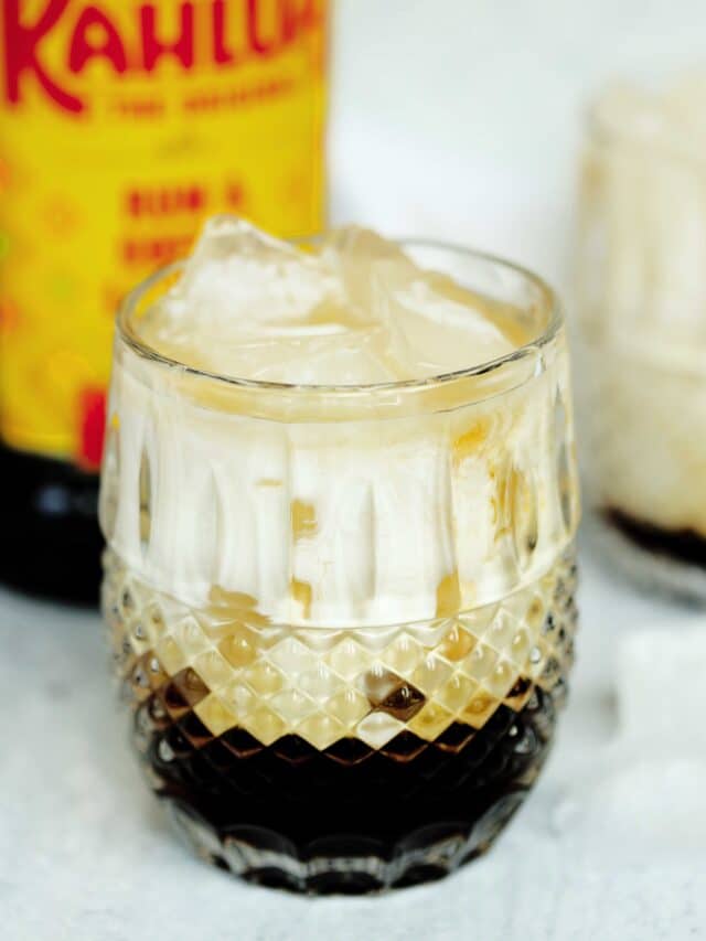 Prepared White Russian in a rocks glass with a Kahlua bottle