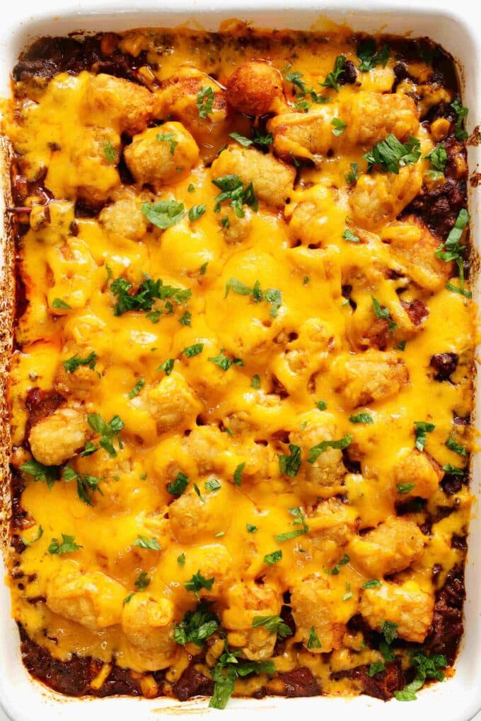 An overhead shot of perfectly cooked tater tots topped with melty cheese.