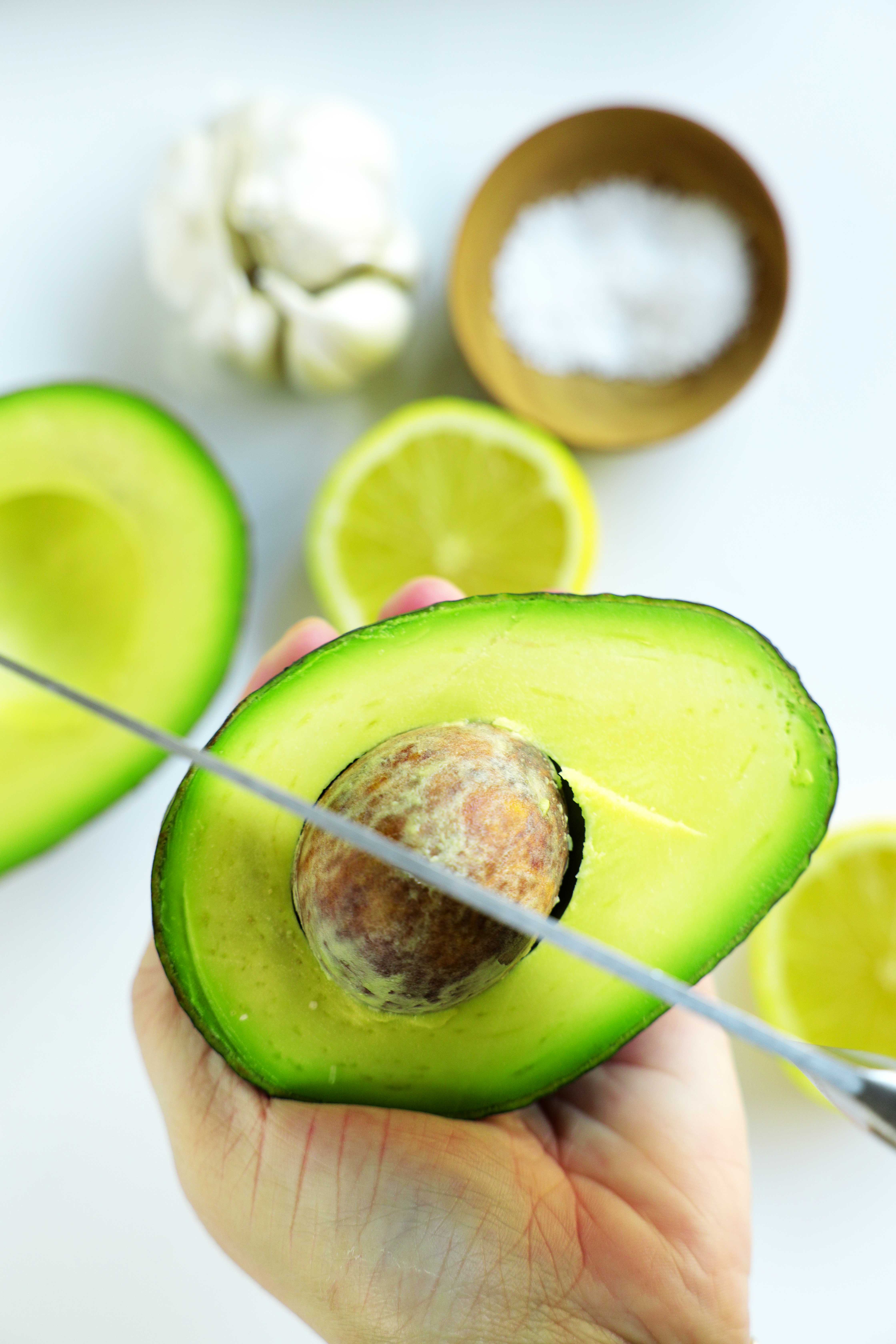 Chef's knife cutting removing an avocado pit