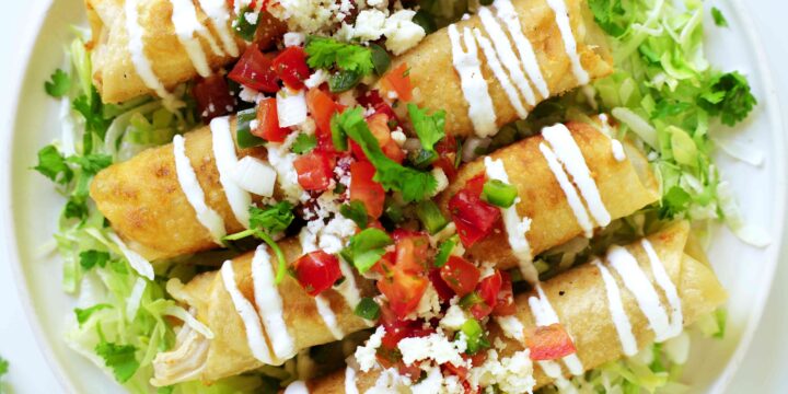 Four Flautas de Pollo with iceberg lettuce, sour cream, pico de gallo, and fresh cilantro