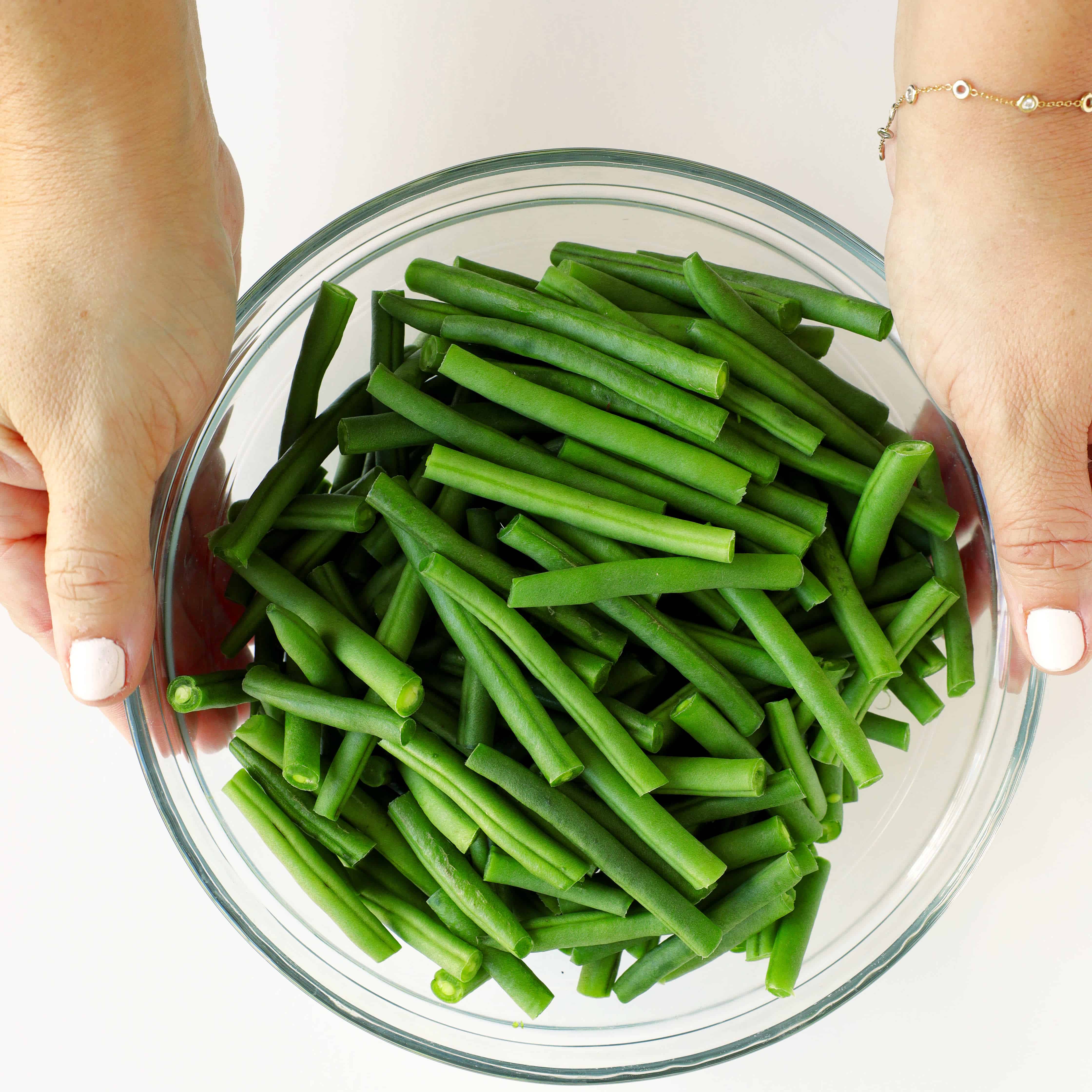 Fresh green beans, trimmed, in a glass bowl