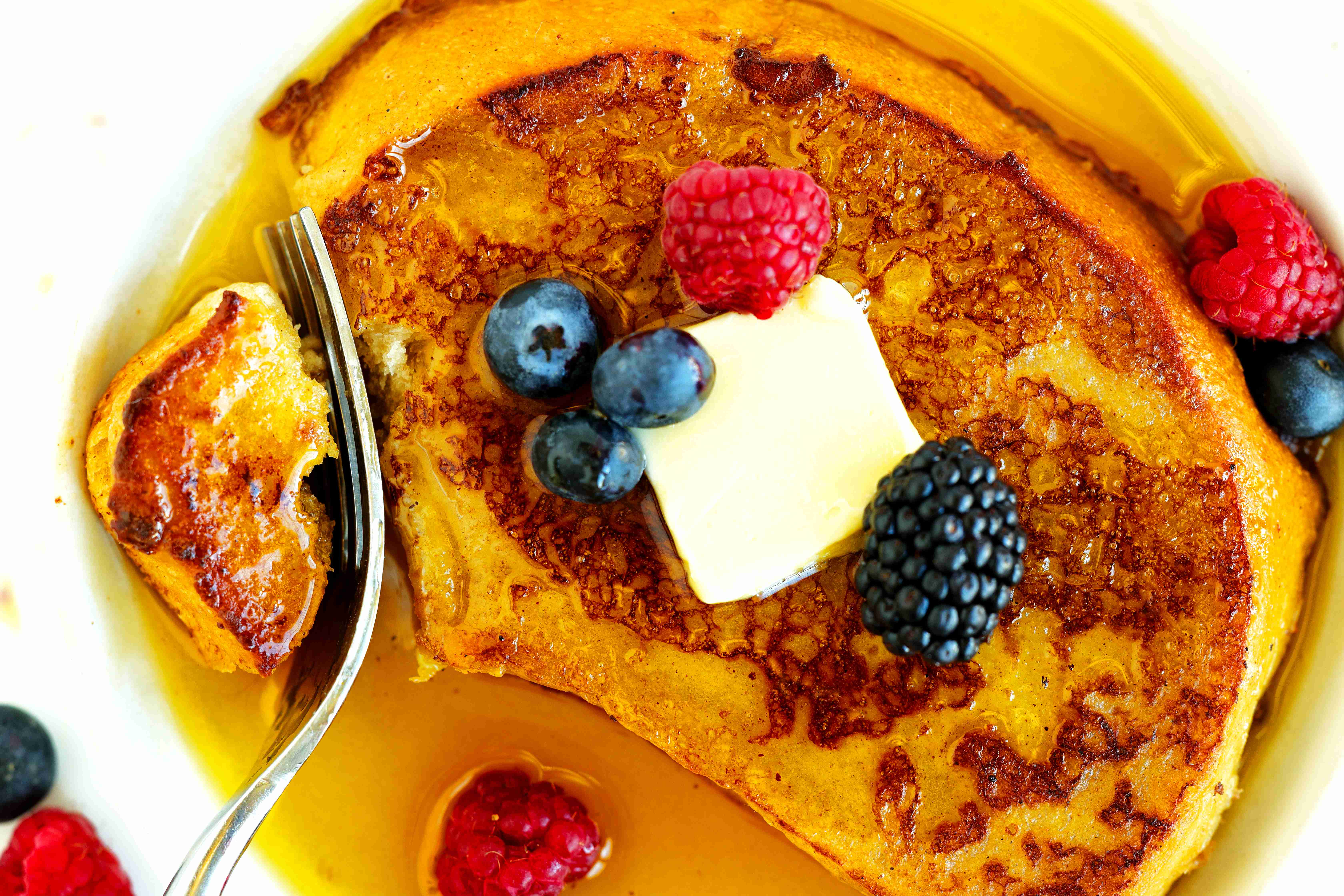 Closeup of Sourdough French toast with fresh berries, butter, and maple syrup