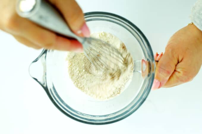 Whisking dry ingredients in a glass mixing cup for brioche French toast