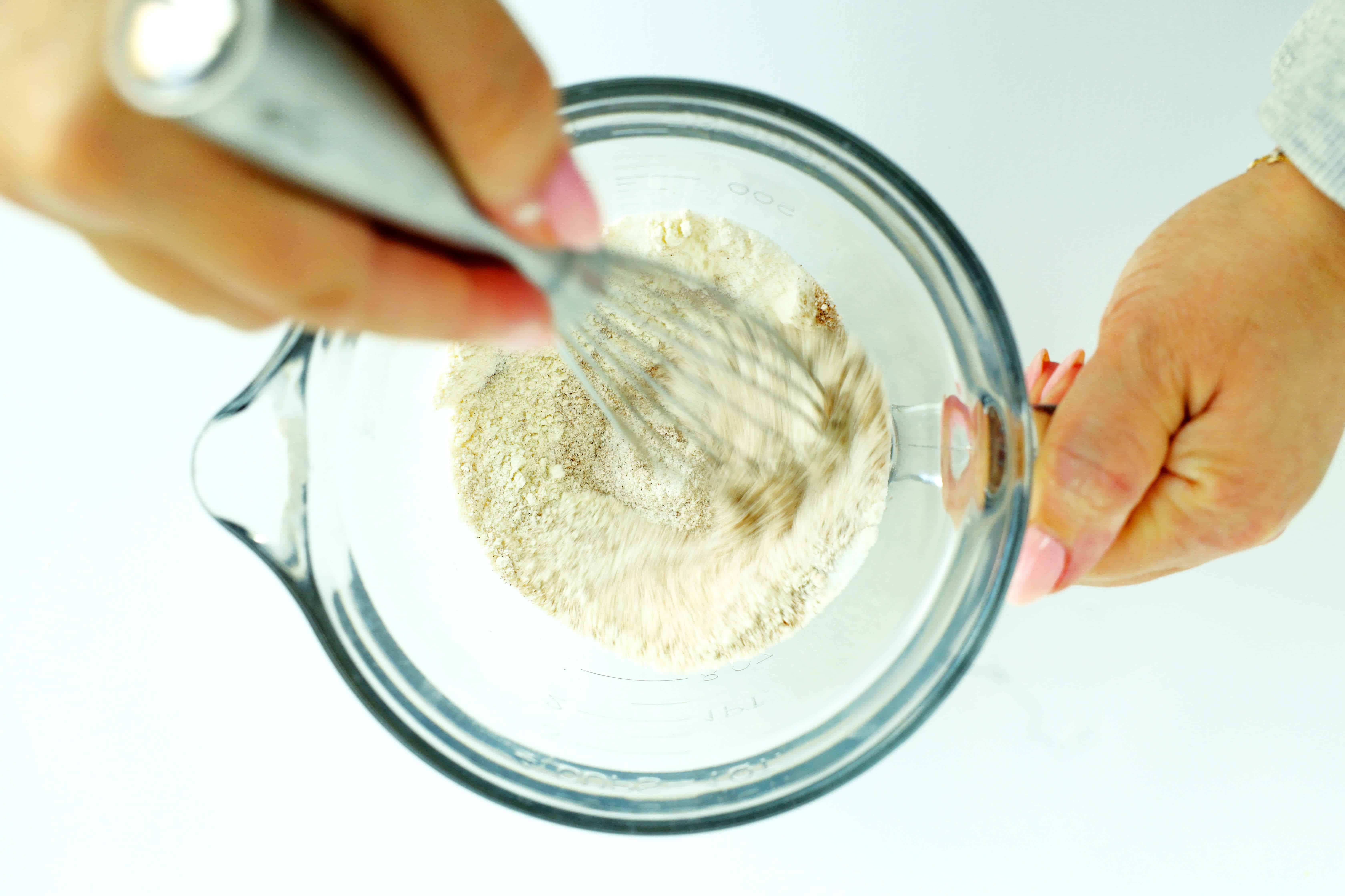Whisking dry ingredients in a glass mixing cup for Sourdough French toast