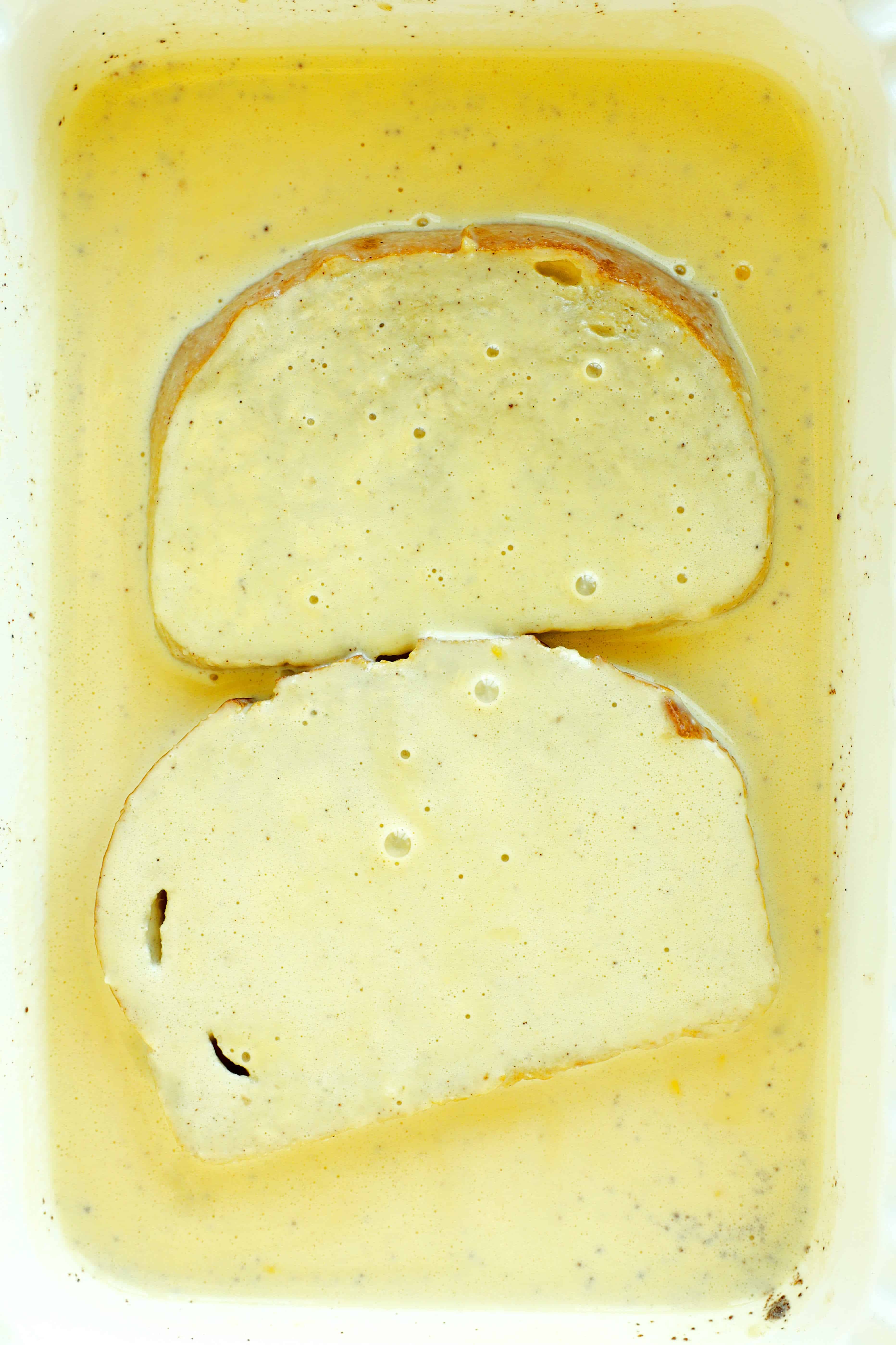 Soaking the Sourdough bread slices in a custard mixture in a casserole dish