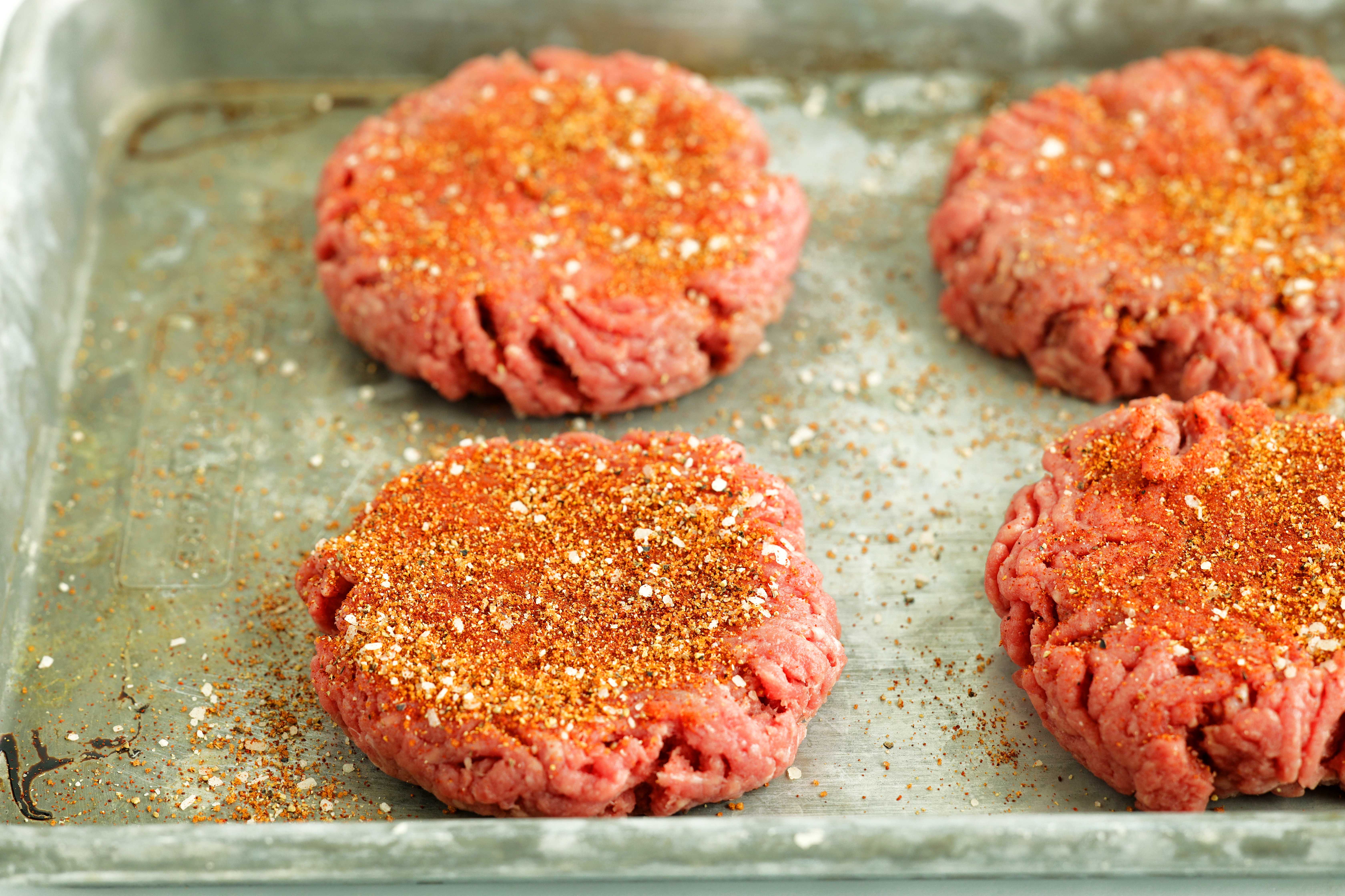 Homemade burger seasoning on raw patties