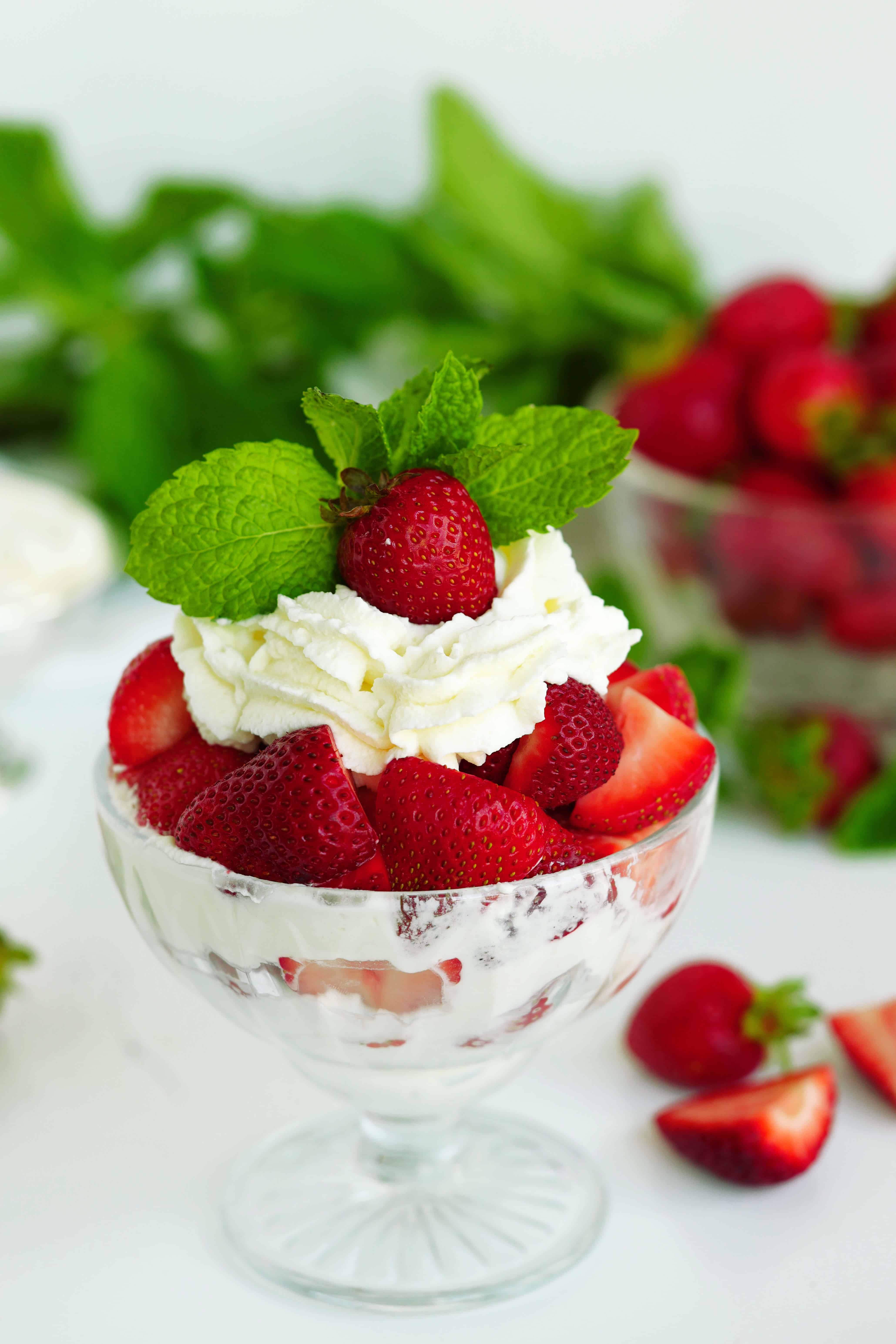 Strawberries and Cream in a dessert bowl, garnished with fresh mint